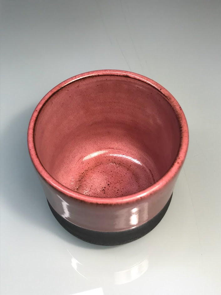 Black clay cup with pink glaze