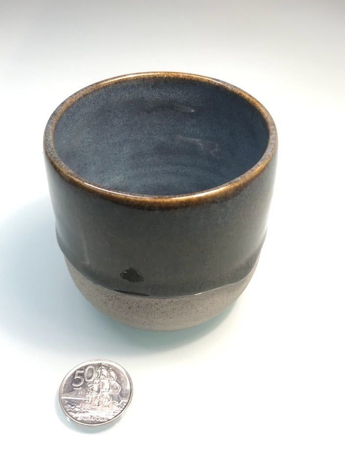 Speckled clay cup with blue and caramel glaze