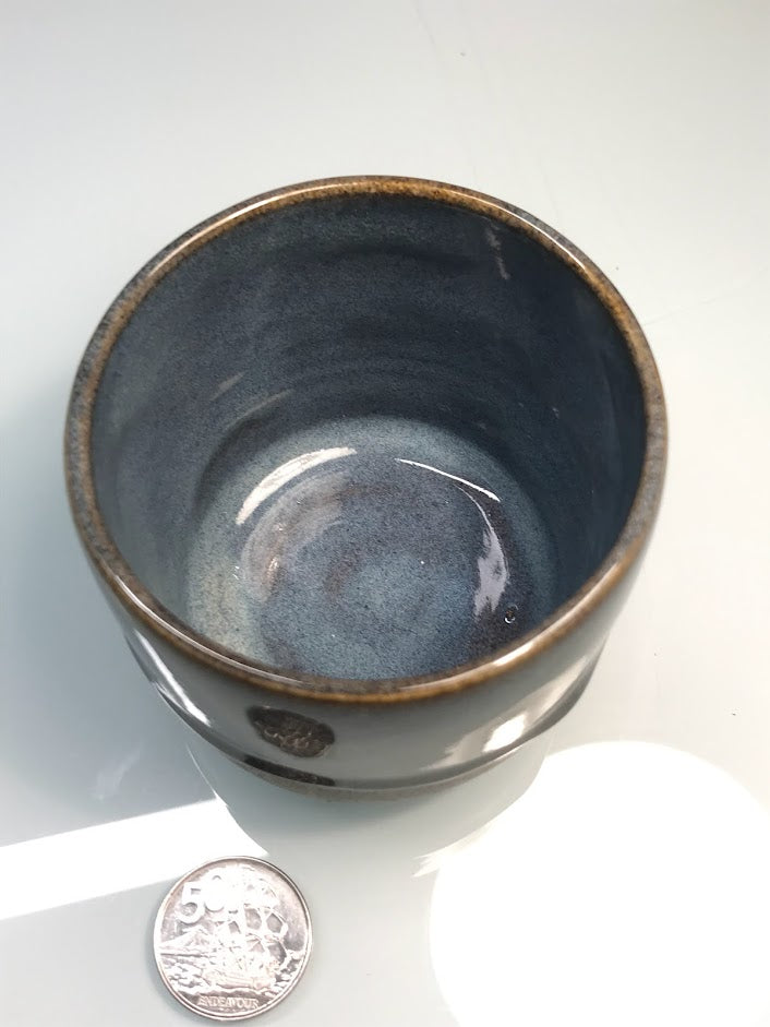 Speckled clay cup with blue and caramel glaze